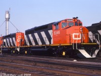 Fresh from the GMD London assembly plant, brand new CN SD40-2W units 5346 and 5347 sit in CN's yard in London awaiting their first assignment - with not a speck of dirt on their plow, fuel tank and trucks from regular service. The two were part of an order of 30 units (5324-5353, GF30t class) built in Apr/May of 1980, and all of CN's SD40-2's bought new came equipped with the CN-designed Canadian Safety Cab (the only railway to order SD40's so equipped). The yellow-painted center bearings were to denote axles with "increased lateral clearance", likely for less wear on tighter track curvature.<br><br><i>Gord Taylor photo, Dan Dell'Unto collection.</i>