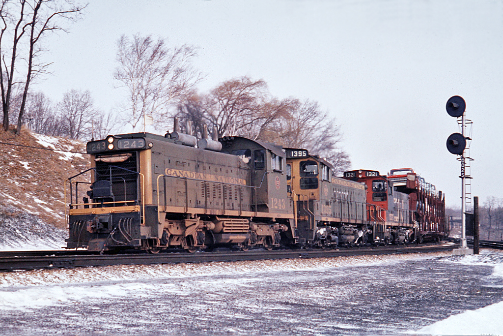 As can be seen by the signal, CN 307 is at MP 0.02 on the north track of the Dundas Sub.  Note the different lettering on the first two units.  Also extinct are the open tri-level auto racks.