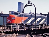 CN 6541 riding the turntable in the sun at CN's Spadina Roundhouse. The Toronto skyline is still relatively low but new construction can be seen.  The Royal York Hotel stands just above the centre of the unit and was opened in 1929 by Canadian Pacific as the tallest structure in the British Commonwealth. The 28 floor structure is dwarfed today by the many buildings in downtown Toronto.    