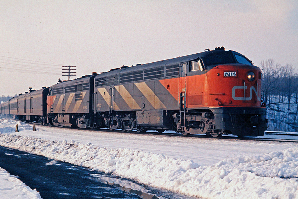 CLC built six of these CPA-16-5 passenger locos for CN along with six CPB-16-5 "B" units. They were 1600hp and geared for 83 mph.  Due to the low number on the roster, it was not too common to find one leading on a passenger train.  CN 6702 on train 146 has passed through the interlocking at Hamilton West (now called Bayview) and will head onto the Oakville Sub toward Toronto.  Note the wheel stops for the siding which no longer exists.