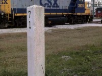 A white mile post marker marks Mile 71 of CSX's Sarnia Sub, adjacent to power parked at their engine shop facilities. The end of the Subdivision is half a mile north near where the line connects with CN.