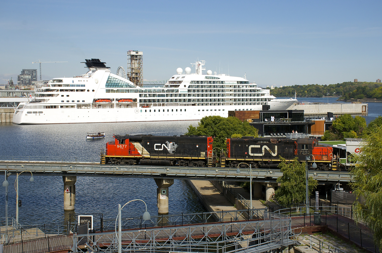 CN 9677 is the highest numbered GP40-2 variant acquired by CN and the last ex-GO unit acquired (ex-GOT 710). Here it leads the Pointe St-Charles Switcher as it switches grain cars on the Bickerdike Pier, with CN 7233. Of note is that CN 9677 is now set for beltpack usage (i.e. remote controlled). In the background is the cruise ship Seabourn Quest.