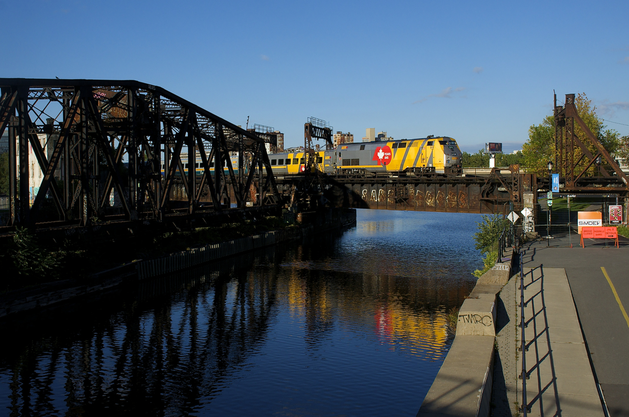 VIA 918 casts a partial reflection in the Lachine Canal as it pushes VIA 64 towards its final destination of Central Station in Montreal. Up front is another P42DC wrapped for VIA's 40th anniversary, VIA 900.