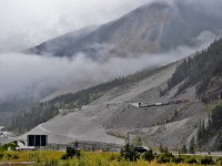 ...looking east up the Kicking Horse Canyon towards the Cathedral Craigs that is lost somewhere in the cloud and rain and snow....
<br>
<br> 
...CP8960 (and CEFX1036) westbound on the downgrade approach to Field, B.C., with a loaded grain train at 20 mph....the tail end has likely just cleared the lower Spiral Tunnel....
<br>
<br> 
September 14, 2018 digital in the B.C. Rain, at the Kicking Horse Canyon Flats,  by S. Danko.
<br>
<br> 
What's interesting
<br>
<br>
….weather was miserable but notable on the B.C.  side of the Continental Divide plus 6c and rain, go east up the hill and over the pass and into Alberta the temperature was +1c and snowing.....
<br>
<br> 
…the image's dominant feature is the Mount Stephen Glacier slide path, the site of many CPR incidents including wrecks due to material sliding onto the right of way....the lower portion of the Slide Path has been graded by the Trans Canada Highway maintenance crews to direct sliding material away from the River and the TCH...in fact it was the National Parks that asked CP to build the concrete snow sheds after the 1986 incident when 17 sulphur cars landed in the Kicking Horse River …. ( the River is between the CPR and TCH at the site of the slide path,  the TCH bridge over the River is visible extreme lower left corner).
<br>
<br>
On the TCH: up the hill, out of sight round the curve and in the cloud (fog) is the Spiral Tunnel Lookout – the view from such is 95% treed out, probably does not matter as the road widening will likely wipe out that lookout...
<br>
<br> 
….plenty of 2018 – 2019 construction on the TCH east up to the Continental Divide to widen the road to four lanes, crews are literally blasting away half a mountain (on the north side) and at that point the CP is on the south side of the TCH...
<br>
<br> 
...driving east up the TCH to the Kicking Horse Pass ( not visible in this image, elevation: 5,339 feet at Stephen, B.C. ) note that a portion of the TCH (above the Spiral Tunnel Lookout) is built upon the original CPR right of way – that grade would be just plain scary to put any train on......in any era..
<br>
<br>
..elevation between the Upper and Lower Spiral Tunnels near Yoho is 4,675 feet....and Field, B.C. Elevation is 4,121 feet
<br>
<br> 
 ..that CEFX1036 unit been on CP over 15 years, got a shot of 1036 at Lovekin !  
<br>
<br> 
Information credit: the book Nicholas Morant's Canadian Pacific: by J.F.Garden
<br>
<br> 
note: Image captured from a public roadway
<br>
<br> 
sdfourty
