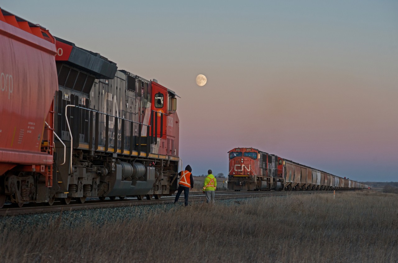 CN 758 and 863 are seen meeting at the east end of Biggar at dusk under a harvest moon.