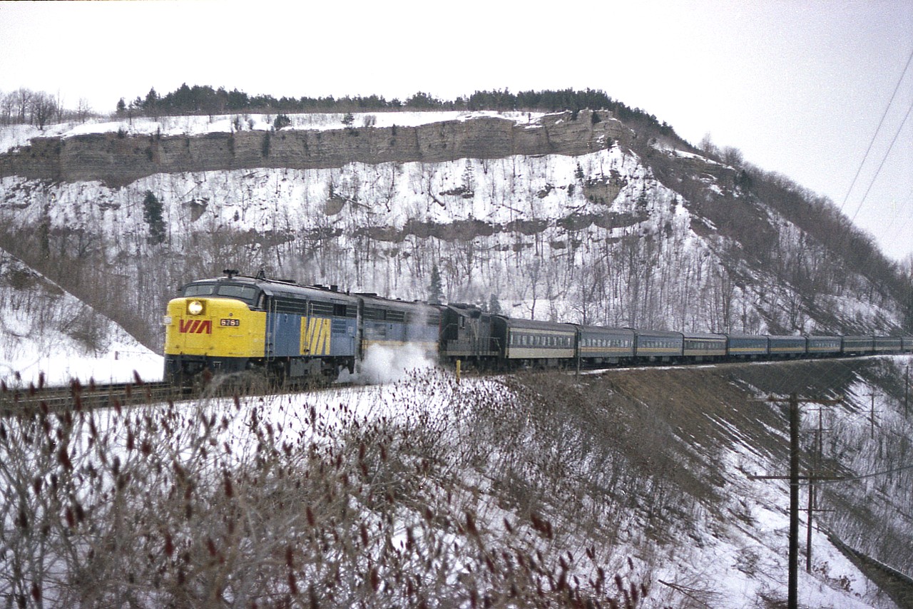 This was such a good shooting location for so many of us. Across from the old Dundas station behind that little MoW shed. Westbounds always looked good with that Dundas Peak in the background, and so even on dull days (which I seem to attract) I tried to find time to spend here. On this typical dull February cold and clammy-type day I caught VIA #75; it had 12 cars in tow behind VIA 6761, 6865 and CN 4102. Visiting this location now, it is so overgrown one would never think this angle was once possible.
