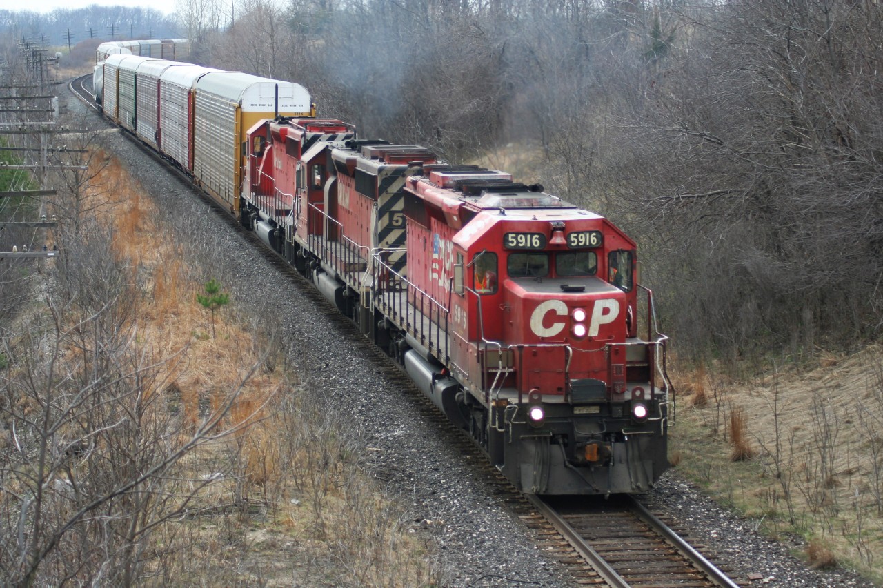 An eastbound Canadian Pacific train with a trio of aging SD40-2's still earning their keep exists the siding at Lobo, after meeting a priority westbound train at Hyde Park.