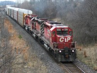 An eastbound Canadian Pacific train with a trio of aging SD40-2's still earning their keep exists the siding at Lobo, after meeting a priority westbound train at Hyde Park. 