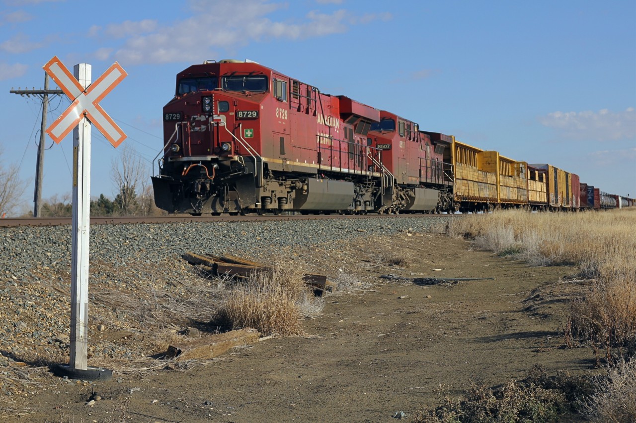 CP 8729 leading CP 8507 sits on the Weyburn sub waiting for a 2 westbounds and an eastbound to pass before connecting onto the Indian Head sub and heading into Moose Jaw. Due to dimensional load clearance restrictions, the train held on the main while the sidings heading into Moose jaw cleared.