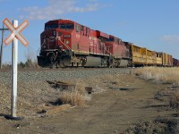 CP 8729 leading CP 8507 sits on the Weyburn sub waiting for a 2 westbounds and an eastbound to pass before connecting onto the Indian Head sub and heading into Moose Jaw. Due to dimensional load clearance restrictions, the train held on the main while the sidings heading into Moose jaw cleared.
