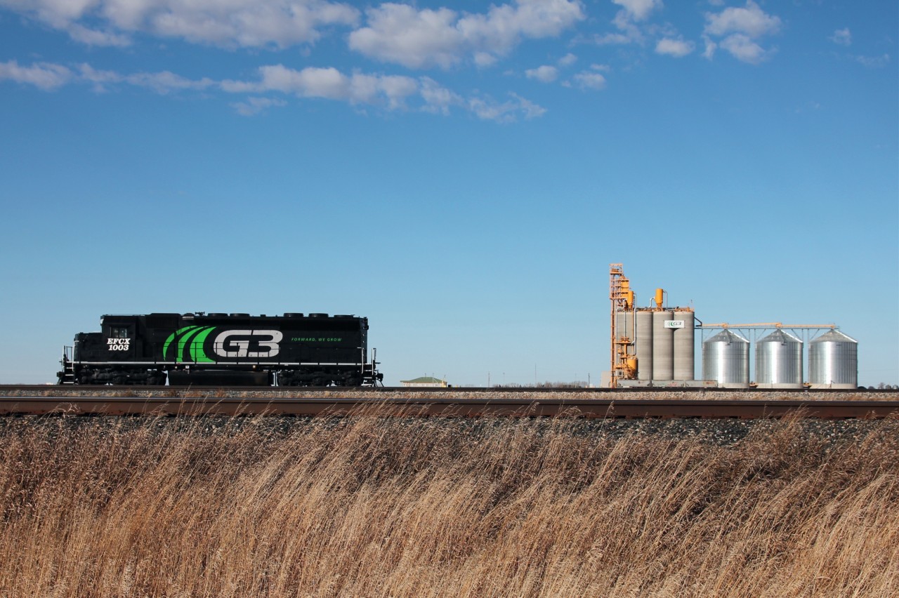 EFCX 1003 sits outside the G3 facility just outside of Pasqua SK. The locomotive is sitting beside the CP Indian Head sub with the facility on the back end of a large U that holds 134 cars, leading to the terminal in the background.