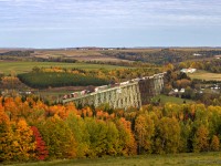 With the Fall season in full force, and eastbound mixed freight crosses over the 3,920 foot Salmon River Trestle, just south of Grand Falls, New Brunswick. 