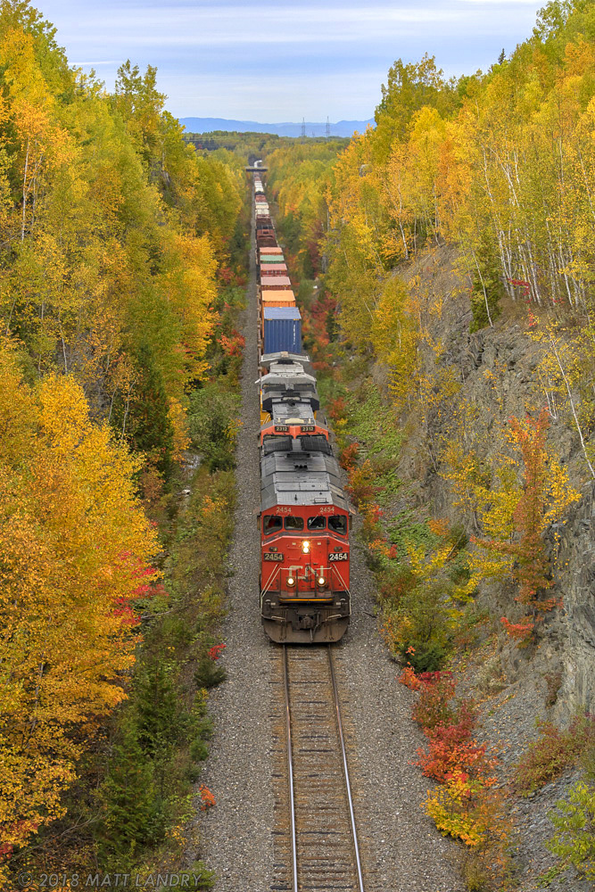 After climbing the steep grade at St Andre Jct, entering the Pelletier Sub, eastbound CN train 306 starts it's slight downhill trek, approaching CN Fourchue in some nice Fall colors.