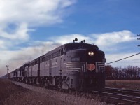 The NYC liked its Alcos, owning 44 FA-1s, 23 FB-1s, 80 FA-2s, 50 FB-2s, 23 RS-2s, 135 RS-3s but only 9 RS11s and 25 RS-32s. These engines were largely used on "Lines East" (of Cleveland) and based out of De Witt (Syracuse, NY). In the early 1960s, NYC began trading in its older Alcos for more modern power--initially the RS-32s and after 1964 on General Electric U25B, U28B, and U30B units.

In this photo, we see three FA-2s, an FB-2, an RS2 and either an RS11 or RS32 leading an eastbound through Canfield.

 