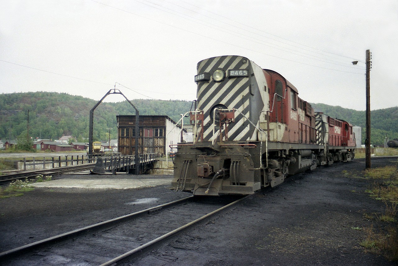 It is the division point between the Nipigon and Heron Bay subdivisions, hence a busy place. Not exactly sure where \on the company grounds this facility used to be, but I do know one thing. The equipment leaked more oils than my old car ever did!!! Local power CP 8465 and 8780 are seen next to a diminutive turntable and engine house (?) on a rather dark overcast day back in 1976. Long gone now, all of it. The job of cleaning up this saturated ground, if it was ever done, must have been quite the endeavour.