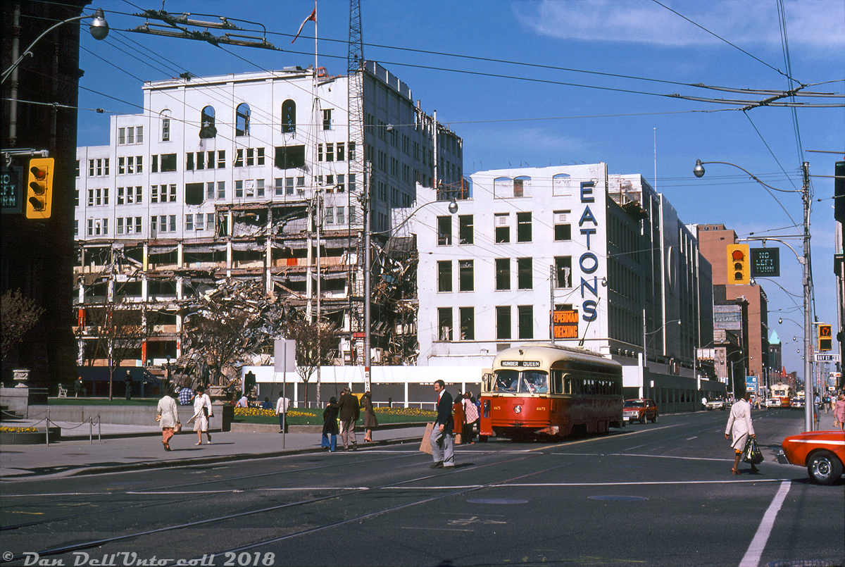 Evening rush hour finds TTC PCC 4675 (an ex-Cleveland A-12 class car built in 1946) stopped to load passengers westbound on Queen Street at Bay Street, operating on the busy Queen route bound for Humber Loop. In the background, the T. Eaton Company's historic Queen Street store slowly meets the wrecking ball, having been replaced by the new million square foot Eaton Centre store that opened at Dundas Street three months earlier. The old store was a collection of smaller buildings bought up by the retailing giant as it expanded over the years and combined into one (with nearby factories and budget stores located on adjacent blocks) and was being torn down by Teperman Wrecking in anticipation of expanding the new shopping centre south to Queen St. to meet up with Simpsons on the south side.

The Eatons Queen Street store was always linked with transit in the area: Queen and Yonge were two busy streetcar routes that brought patrons to and from Eaton's doorstep for decades, and when Toronto's Yonge subway line opened in the mid-1950's, Eatons advertised a quick and easy connection between its Queen and College St. stores via their respective subway stations. In addition, "City Hall Loop" (an on-street loop for Dundas cars) looped around a number of Eaton's factories and storefronts to the north-west, removed when the area and local streets were re-configured when the Eaton Centre went in.

Robert D. McMann photo, Dan Dell'Unto collection slide.