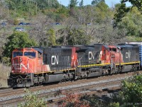 The head end of CN train 421 emerges from tree cover, rolling westward out of Aldershot Yard approaching CN Snake (Road) where it will rejoin the CN Oakville Sub. Usually 421 departs from here too early in the morning for me.<br>
Powering the train are CN 5758 (GMDD SD75i), CN 2007 (GE Dash 8-40C) and CN 2444 (Dash 8-40CM Draper taper cowl). <br><br>
For those who know this spot, cooler weather has diminished the local tick hazard, but precautions are still advisable. Only wildlife seen was a garter snake.
