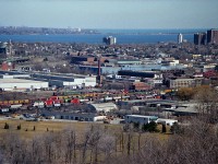 Although this image was taken 3 months after the TH&B was incorporated into the CP, it was still TH&B to me. This overview of the Aberdeen Yard is interesting. For viewers not local, that is Aldershot in the distance on the other side of Hamilton Harbour. On the left is the Cathedral Basilica of Christ the King, a noted landmark; and that is King St (Hwy 8) running east/west in front. The ramp is to Hwy 403. In the foreground,the old Aberdeen Yard looks full. Of note is that green coach car...I was not aware of it back then.(reporting mark??) The old yard is 'dead-ended' now; the track used to continue to Brantford until a washout doomed the line back in 1990. On the right side in the image is the old TH&B shop buildings, the roundhouse, turntable and some CP power. These buildings were razed in early 1992.