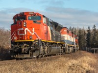 CN 8902 (EMD SD70M-2)with help from BCOL 4620 (GE C40-8M),CN 2618 (GE C44-9W) leads Q120 around a curve at Mackay’s siding heading west to CN’s Rockingham yard