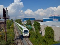 Early in the process of rebuilding the Humber bridge on the Oakville Sub a GO Transit equipment move is seen passing through industrial Etobicoke on the Canpa Sub as it heads to the Oakville Sub to back into Willowbrook Yard