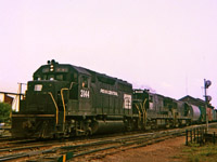 Train LS-3 departing St. Thomas with PC 3144, P&LE 2810 & 2607 on a hazy summer afternoon. My Instamatic recorded the scene and was not perhaps up to the task. It's all gone now, double track main ripped out and the other railways in the area long gone. Travelling that day with Bruce Mercer on one of our many jaunts around southern Ontario.  Bruce kept copious notes of trains seen and was able to provide me with the locomotive numbers, train symbol and date etc. I suppose if asked, Bruce could provide a car count and caboose number on this train. Thanks.