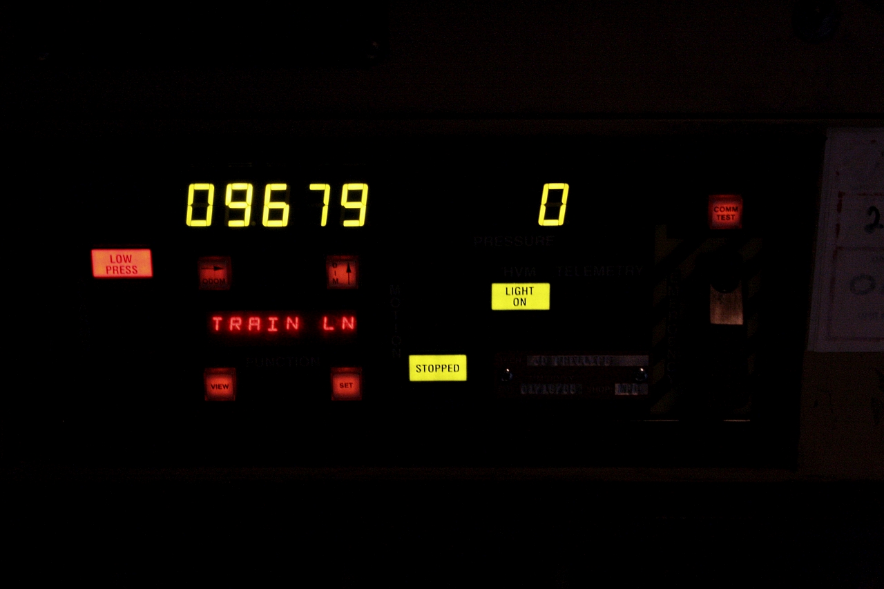 On BCOL 4618 a view of the Central Display Unit (CDU) which relays info to and from the Sense Braking Unit (SBU) on the tailend of the train. At the time this image was taken we were stopped at Colebank doing some work at Pinnacle Pellet plant which was a fairly new operation making heating wood pellets for export. We were cutoff from the train and the CDU is displaying a "low pressure alarm", train length dialed in at "9679" feet, "0" air pressure on the rear and the SBU light (marker) is "on" and the rear of the train is "stopped".On the right just below the "comm test" button is the toggle switch for emergency brake application on rear of the train.