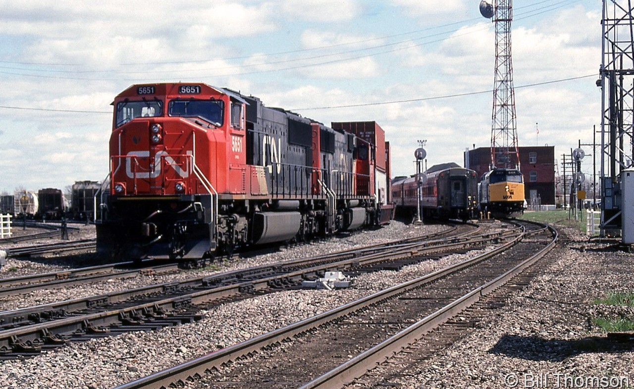 Another one of the CN freights detouring over CP: CN SD75I 5651 and SD70I 5609 lead a westbound on CP's Belleville Sub, as VIA trains 42 and 43 make their stops at the platform by the station.
