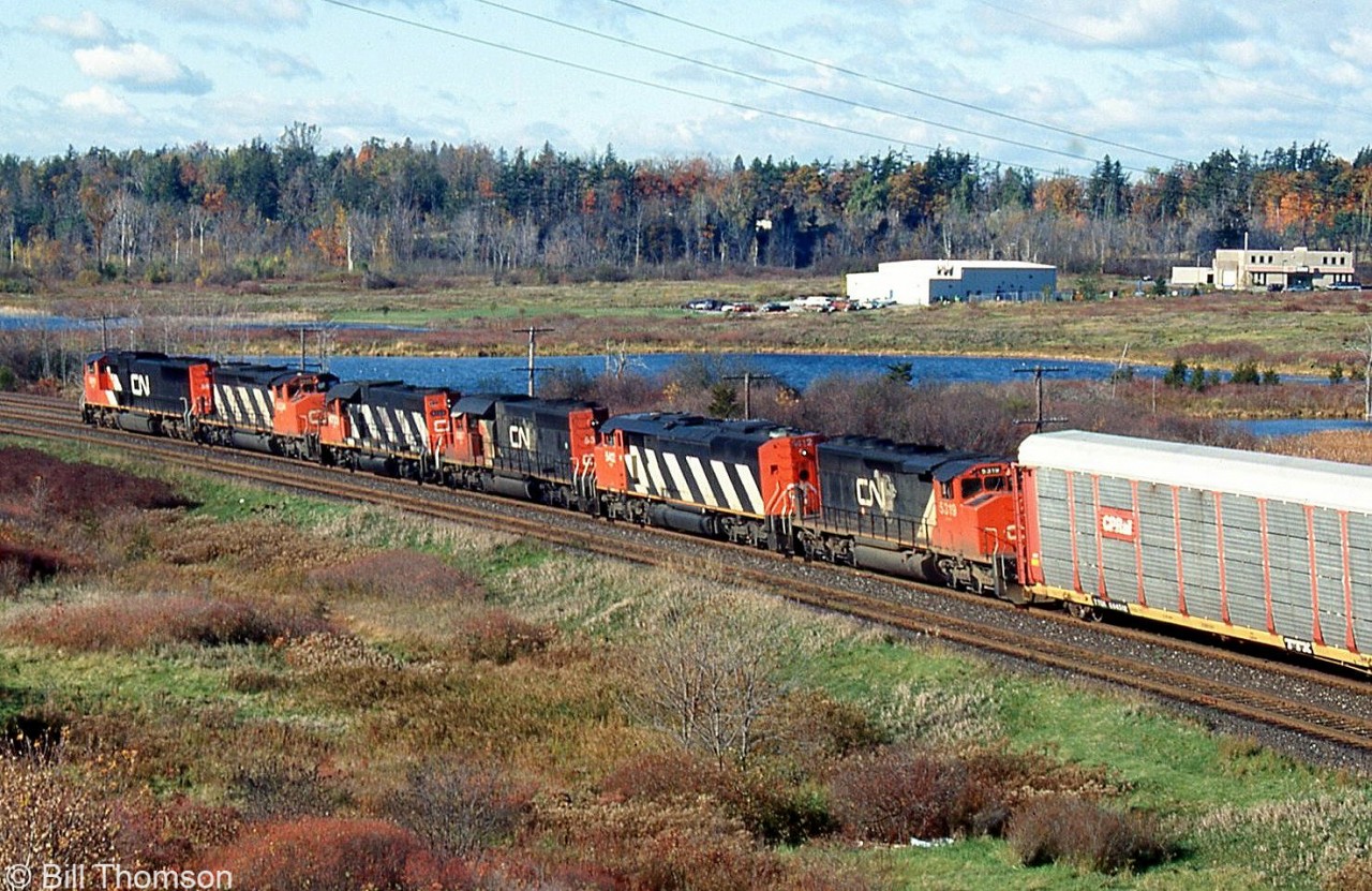A westbound CN freight approaches the VIA Station at Kingston, with six units on the head-end including an SD75I, SD40-2W, GP38-2, SD40-2, SD50F and another SD40-2W.