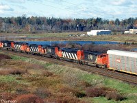 A westbound CN freight approaches the VIA Station at Kingston, with six units on the head-end including an SD75I, SD40-2W, GP38-2, SD40-2, SD50F and another SD40-2W.
