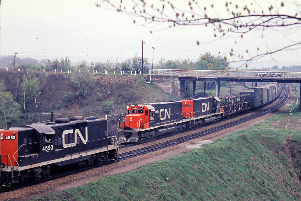 Old meets new.   It is spring of 1968 and CN 4593 west meets SD-40's CN 5047-5046 east at the Plains Rd. bridge.  Looks like auto parts on the head end possibly destined for Ford in Oakville.
