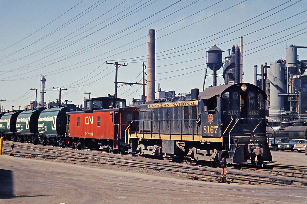 Sequence 3 of 4   CN 8167 has been tacked onto the tail end of the Dofasco ore train at Ottawa St. on the N&NW Spur.  It will pilot the train in a reverse move into the Dofasco plant where the loaded cars will be set off and another unit train of empties will be picked up for return to the mine.