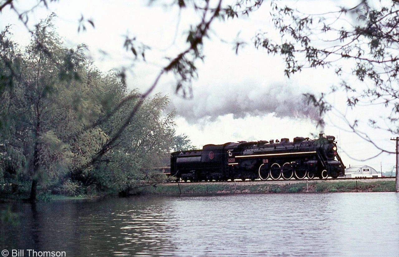 CN Northern 6218 passes through the light rain with an excursion train, as viewed from across a pond at Brunner (located along the CN Newton Sub south of Milverton and north of Stratford).