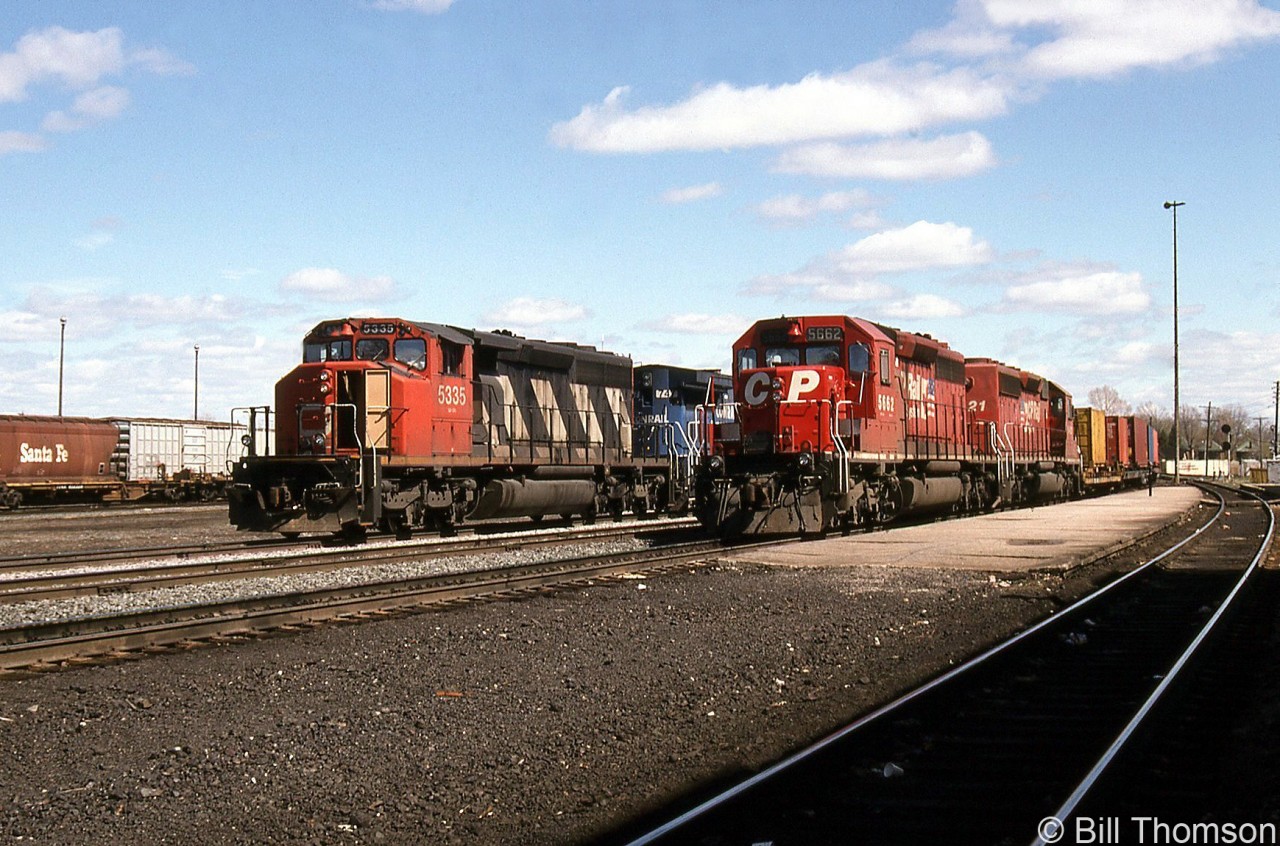 A CN derailment in May 1997 forced a few CN trains to detour over CP, passing through Smiths Falls. This resulted in a few scenes of mixed CN, CP and VIA trains together. Here, CP 5662 and CN 5335 (with CR units trailing) are seen heading up two westbounds by the platforms at CP Smiths Falls station.