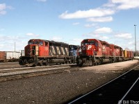 A CN derailment in May 1997 forced a few CN trains to detour over CP, passing through Smiths Falls. This resulted in a few scenes of mixed CN, CP and VIA trains together. Here, CP 5662 and CN 5335 (with CR units trailing) are seen heading up two westbounds by the platforms at CP Smiths Falls station.