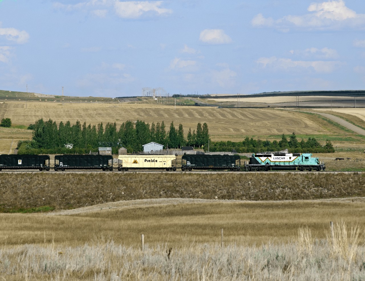 Having just loaded coal at the mine, Luscar Coal's shuttle heads south over a five mile line to the Saskatchewan Power Co. station just east of Coronach in the Poplar River Valley