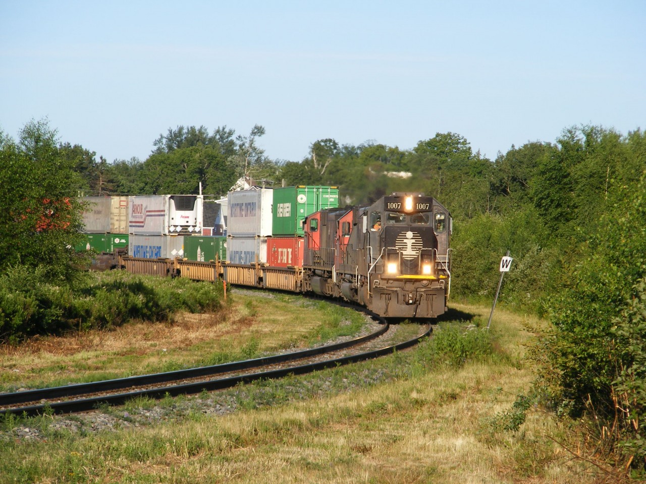 An Illinois Central SD70 locomotive leads CN train Q120 from Toronto, ON to Halifax, NS through the University town of Sackville, NB.
