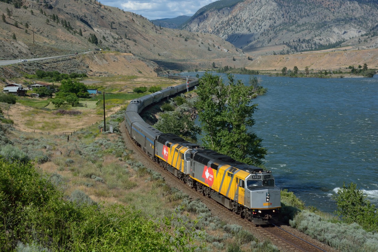 VIA 1, the Canadian, is led by two VIA 40th Anniversary-wrapped units, as it rolls west along the bank of the Thompson River near Martel.