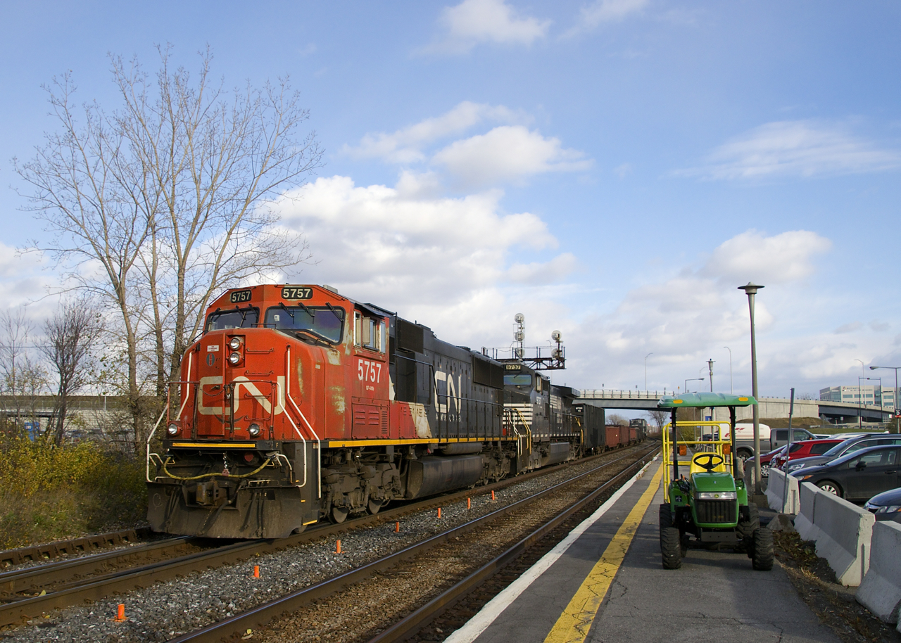 CN X321 with CN 5757 & NS 9737 for power is passing a baggage cart at Dorval Station with a short train consisting mostly of gondola's. They will lift more cars further west at Coteau, before continuing towards Toronto.