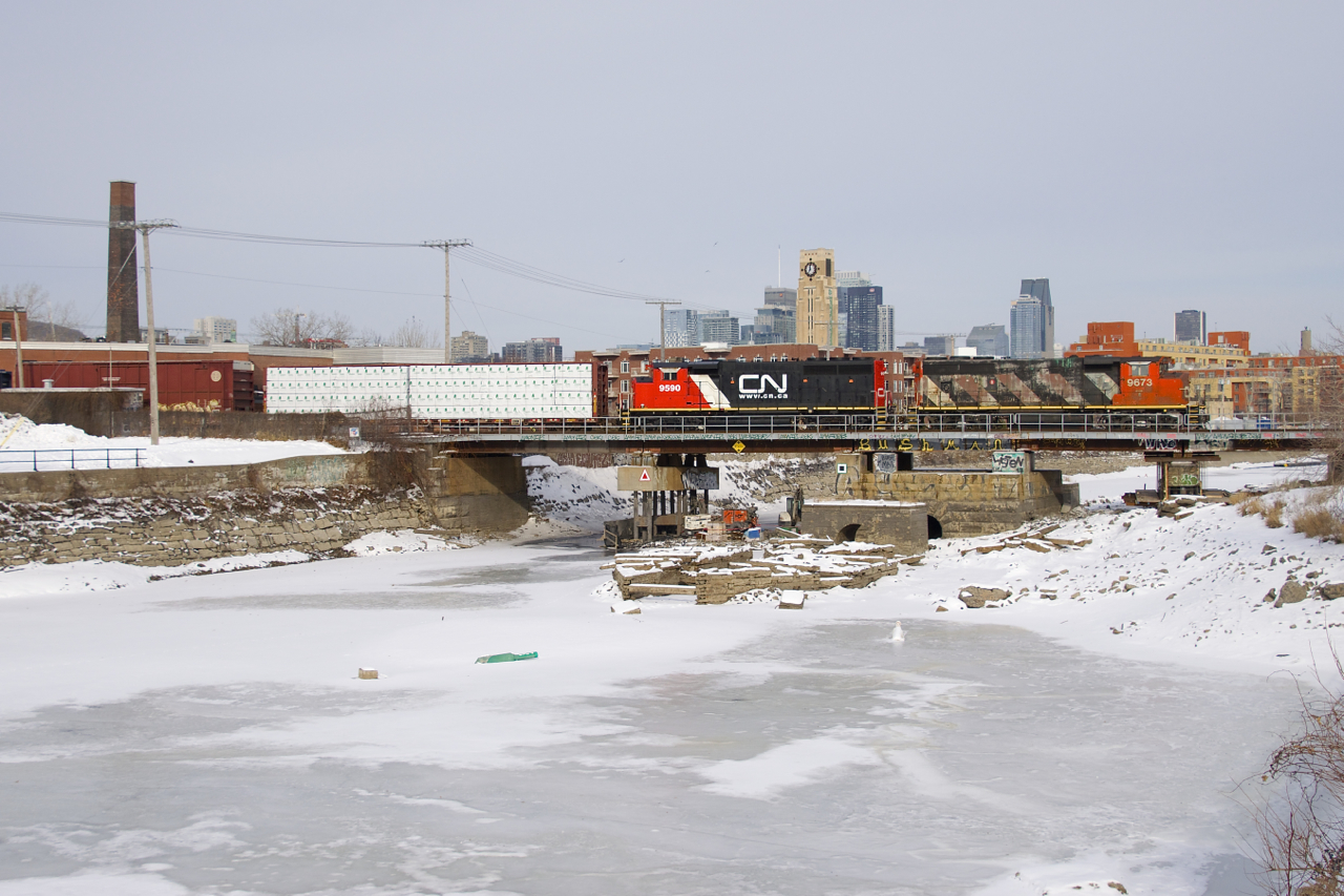 CN 324 has GP40's in very different paint schemes for power as it crosses the Lachine Canal with 51 cars to interchange with the NECR at St. Albans, VT. Leading is ex-GO Transit GP40-2(W) CN 9673 in a faded zebra paint scheme, while trailing unit GP40-2L(W) CN 9590 is quite clean and sports CN's current website paint scheme.