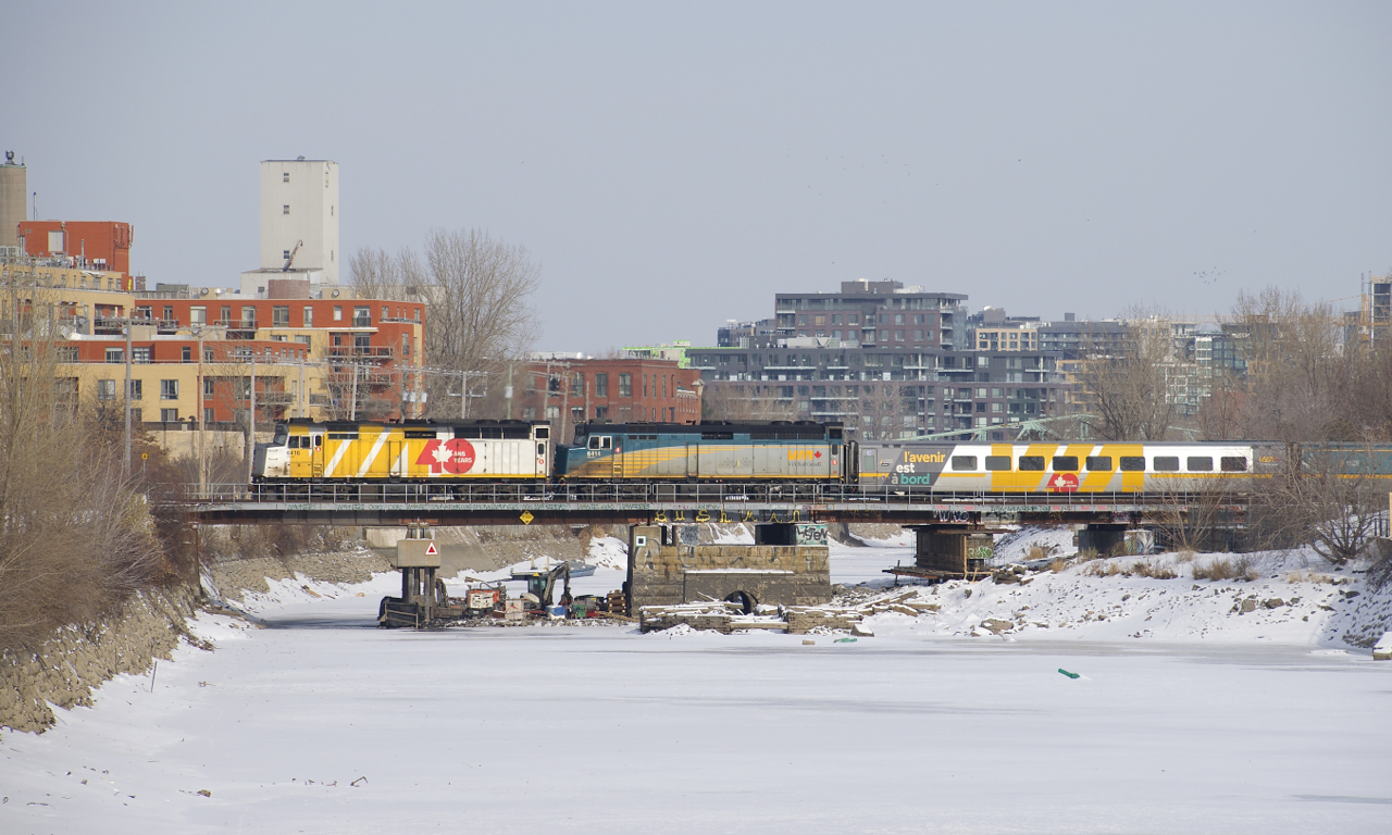 VIA 35 with wrapped VIA 6416 and unwrapped VIA 6414 for power crosses the Lachine Canal, with a wrapped LRC car first out.
