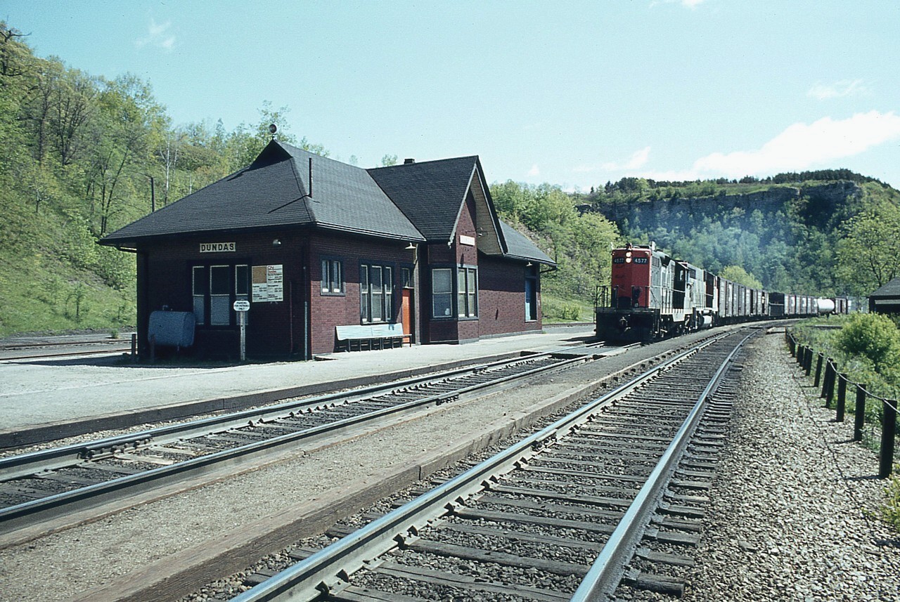 This is one of my favourite scenes from Dundas. The soft greens, the clean grounds and rather impressive old station gives a feeling of peace and tranquility. I'm surprised I cannot see anyone up on the Peak. So it must be an early weekday image. I do not have an exact date.  CN 4577 and an unidentified GP40 widecab make their way west with a short freight. Perhaps a local to Brantford. And yes, I looked up the line west before I stepped out briefly to grab this image.:o)