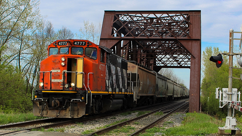 It was my first chase of 514 and it had been raining hard all day, so we were thrilled when the rain finally stopped and a little sun appeared. Here, 514 has finished work at Thamesville and is crossing the Thames River on its way back to Chatham. Hoppers from Blenheim are on the head end.