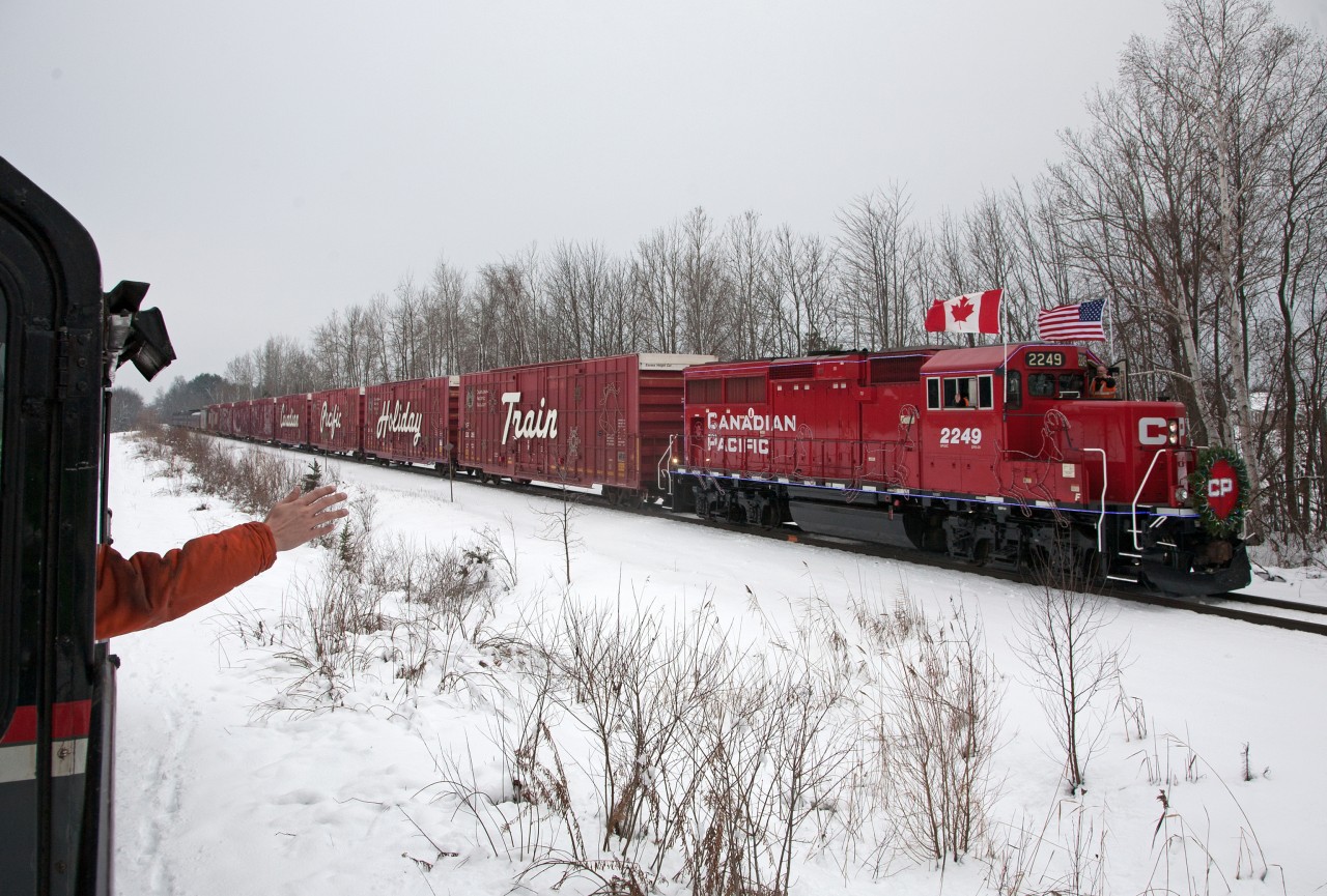 CP's Holiday Train needs no introduction.  It's become a "must see " event and does so much good for food banks right across the country.
Just prior to it's next stop at Midhurst, just outside of Barrie Ontario, the crews of the Cando Rail Services local and CP's Holiday Train exchange waves in the true spirit of the season and railroading.
