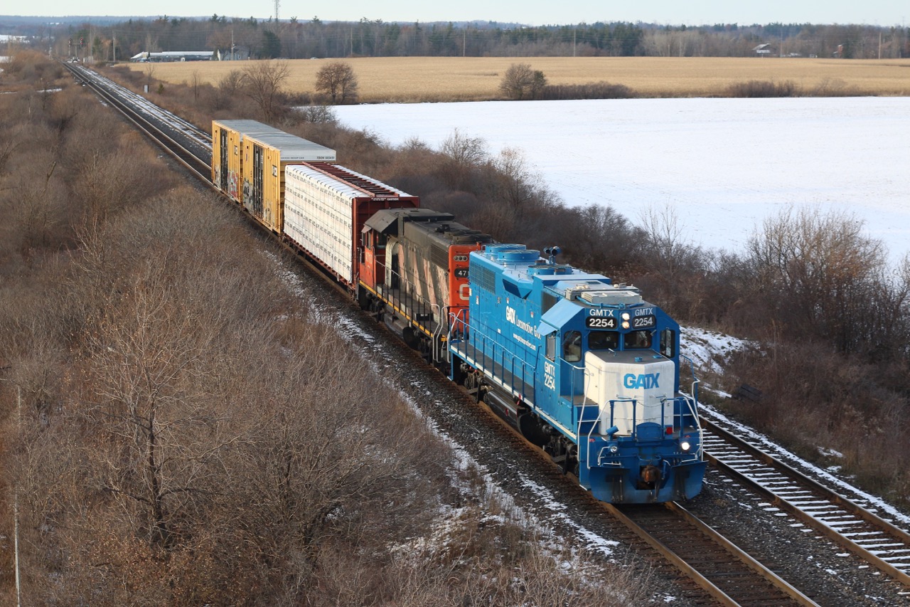 CN local 551 is seen heading back towards Aldershot as it departs Milton with three cars in tow after meeting train 422 with a couple of dimensional loads. The centre beam will be left at Tamarack Lumber in Burlington on its way back. Lead unit GMTX GP38 2254 is wearing similar colours to those it wore while working for the GTW so many years ago as GTW 5810, and is seen once again working for its old parent company Canadian National.
