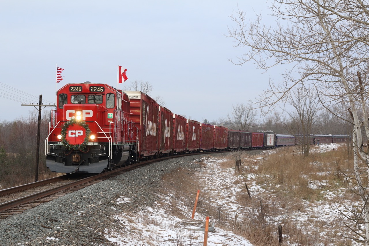 With shows at both Milton and Hamilton behind them. The annual CP "Holiday Train" (American Train) is rolling westward towards its first show of the day at Galt. Train 246 is holding on the main up ahead at Puslinch as the "Holiday Train"prepares to take the siding briefly before continuing on. The sweeping curve here at Victoria Road allows the whole train to fill the frame. A few spectators have taken to the hill in the background to take in the festive view.