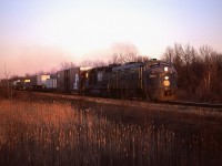 On the evenings I was lucky enough to catch the westbound train out of Fort Erie, it was often close to dark when it left and photos were unattainable. Sometimes, though, the sun stayed above the trees long enough for me to grab an image shooting at 125th or so. This was one of those evenings. It is the very last gasp of sunlight here; the train has just cleared CN Duff as it leaves Fort Erie (see signals on the left background). I am standing by Pettit Rd crossing between the CN and the old CSX line, as N&W 3725 and 4142 accelerate west.