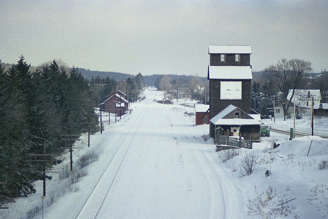 Quite a few years ago now I was sitting at home in St. Catharines reading the Globe & Mail and there was an article referring to the demolition of the CP Pontypool station, planned for early in the New Year. Like a good scout I put down the paper, grabbed my camera and a coffee and did the 100 or so mile drive up to this little place. Right thru Toronto on a Tuesday morning. Like **** I would do that now.  Anyway, this image off the Hwy 35 bridge over the CP line looking east shows the station on the left, the grain elevator on the right, and some trackage under the snow. I understand part of the station lasted at least into the summer of 1977 and the grain elevator....is it still there?  I will post a photo just of the station itself later on for those of you enjoy such.