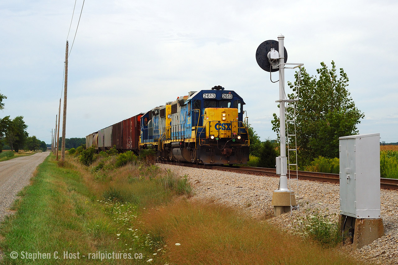 D724 is southbound on the Sarnia Sub passing the approach signal to the Fargo diamond with the CASO Sub. 724 always ran in the mid to late afternoon so thank god it wasn't sunny. Fans from this era would remember the detectors on the CSX Sarnia sub at mile 12, 33 and 51. Here's a recording of this oddball, just north of this spot at mile 12: Here. For more recordings, including the RTC and Station Operator/Clerks (friendly Skip!) see this link here - photo of CSX D724 at Wallaceburg