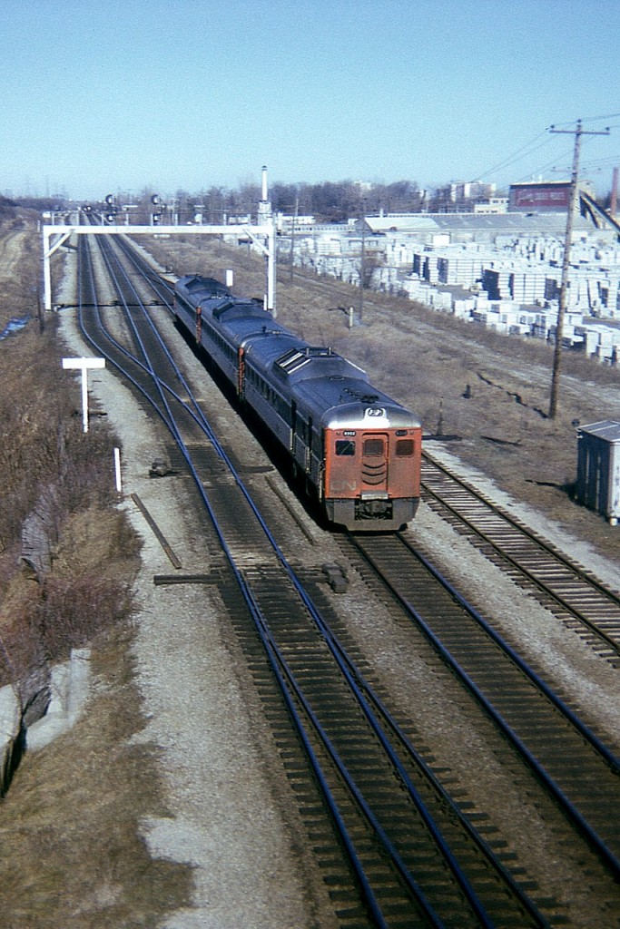 This is about as old as they get in my personal collection. Early 1974. Here's the CN Budds as witnessed from Waterdown Rd bridge, back in the day when one could stand there and not be driven mad by vehicle traffic. It was actually rather quiet. To the left of the big overhead signal structure is where more track and the Aldershot GO station are located today. I like this shot for the massive storage of concrete blocks, all part of the old J.Cooke Concrete Blocks Ltd that used to be located here. Don't know why they left or where they went. 
This scene is an interesting one to recall the next time you drive over the CN mainline out in Aldershot. Time machine, anyone?