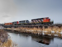 The morning fog has just began to dissipate as CN SD40-2W 5299, IC GP50r 3140 and CN SD40-2 5381 coast across a small wooden trestle on CN's Coronado Sub with Fort McMurray bound train L557 in tow.